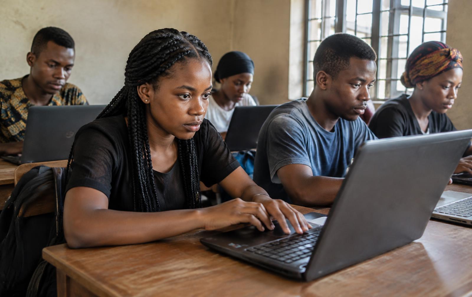 Young people working on laptops in a community computer centre